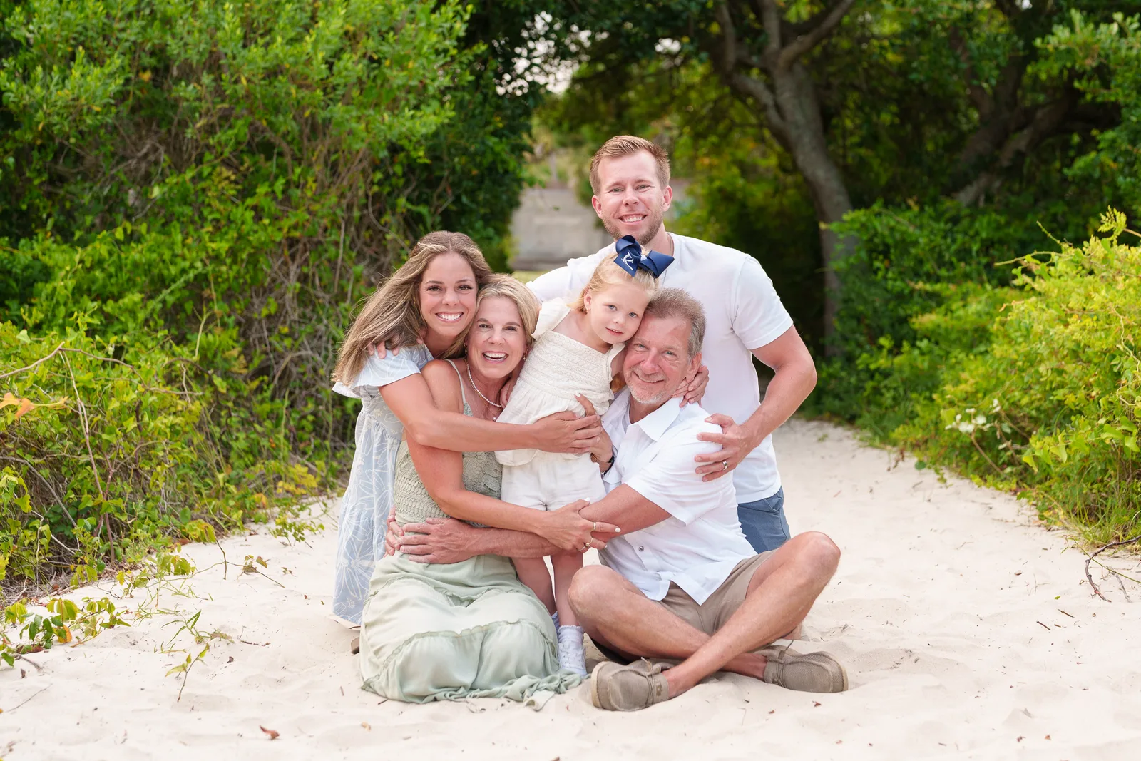 Family of 3 with grandparents sitting on the path to the beach - Huntington Beach State Park