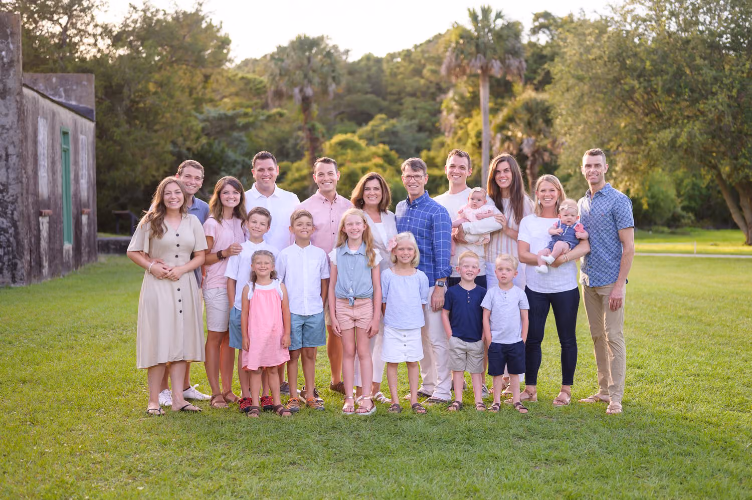 Large family of 20 standing together on the lawn near the Atalaya Castle at Huntington Beach State Park