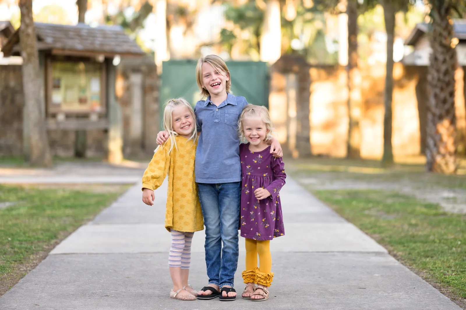 Brother hugging his two little sisters by the castle doors - Huntington Beach State Park