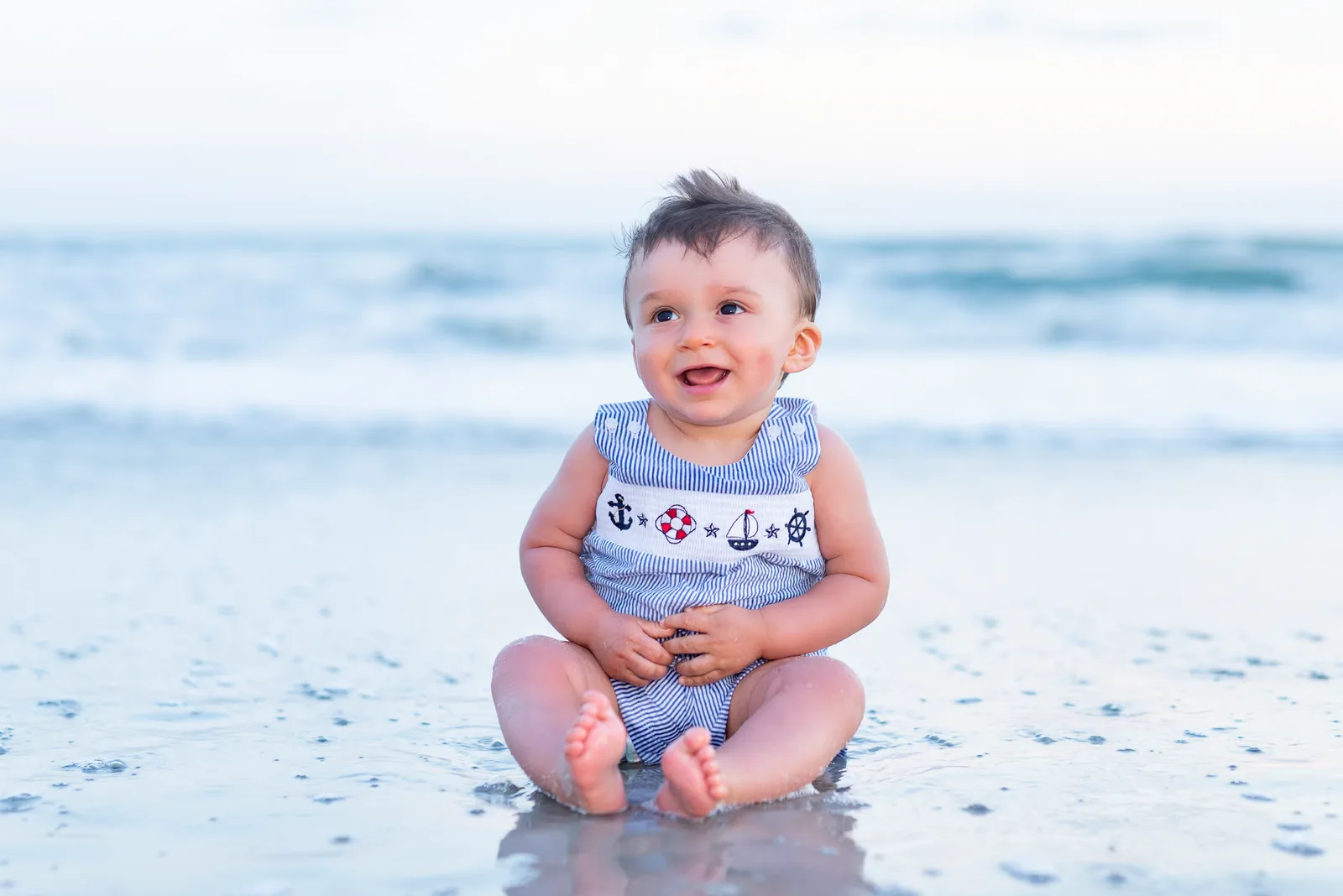 Happy baby boy sitting by the ocean - Huntington Beach State Park