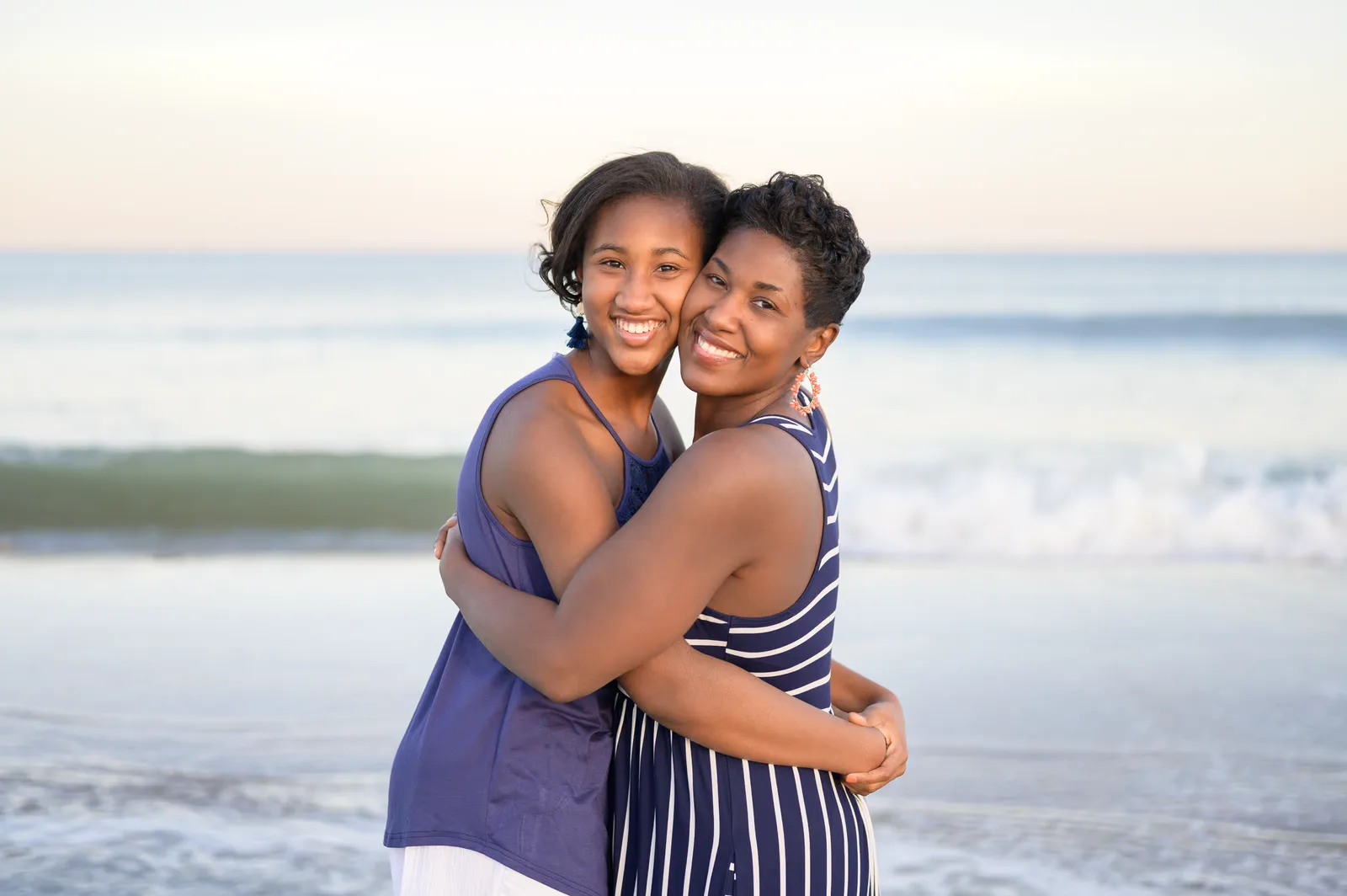 Mom and daughter hugging in front of the ocean - Huntington Beach State Park
