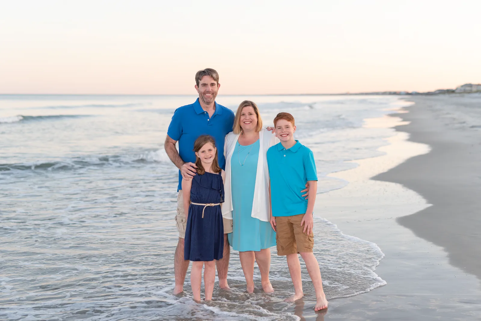 Happy family of 4 standing in front of the ocean - Myrtle Beach