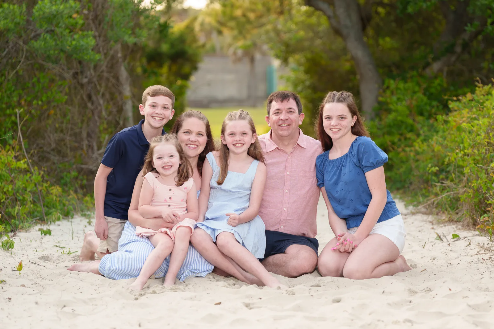 Cute family of 5 sitting on the path to the beach - Huntington Beach State Park