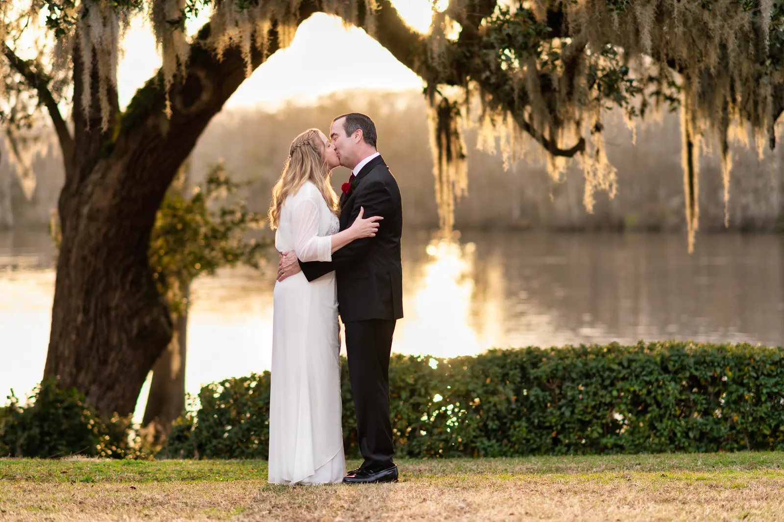 Older couple under the moss with sunset reflection in the river - Wachesaw Plantation