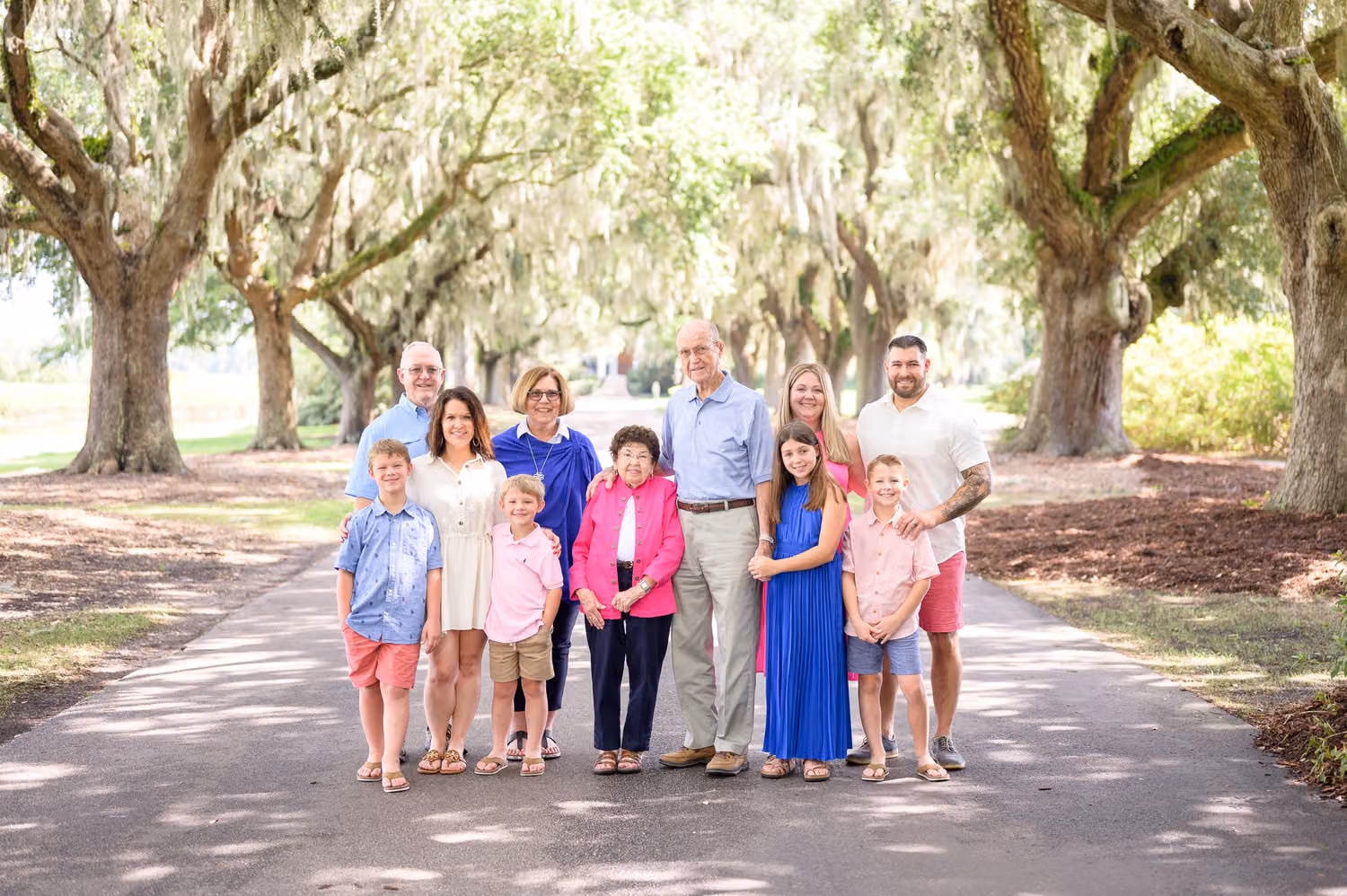 Four generations lined up on the avenue under moss-draped oaks in morning light at Caledonia Golf & Fish Club