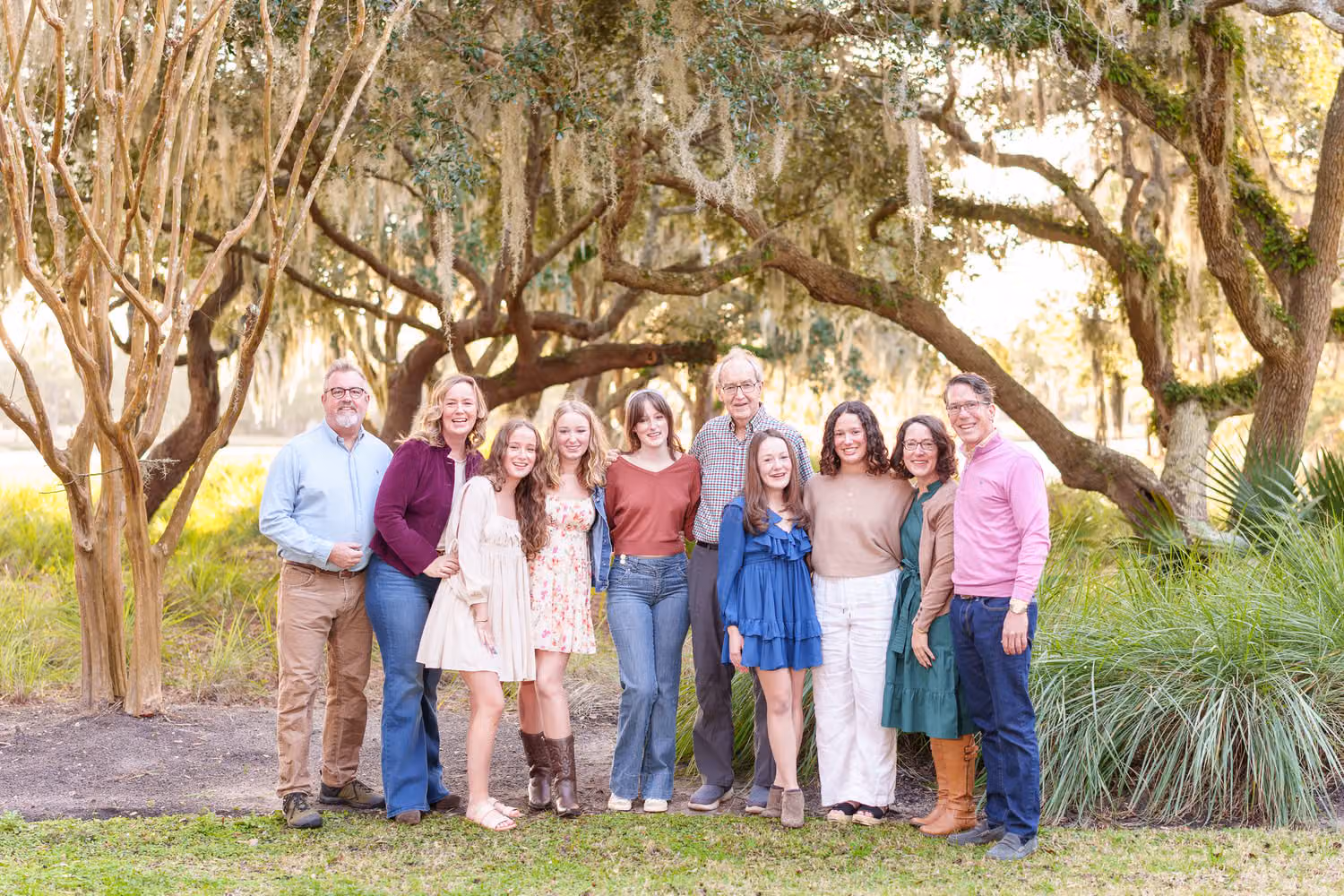 Big extended family standing on the lawn under spreading oak trees by the golf course at DeBordieu Colony