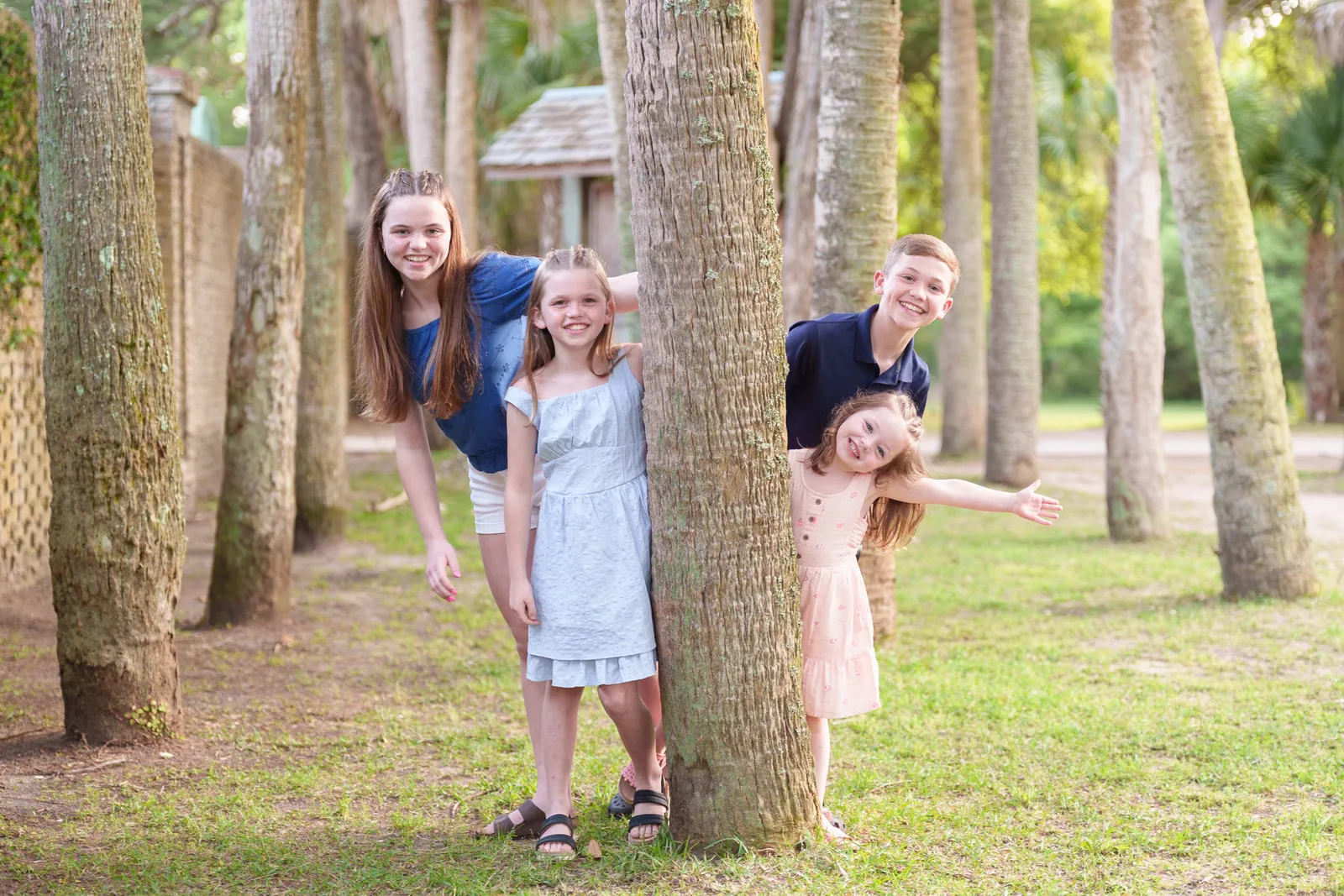 Kids leaning out from behind the trees - Huntington Beach State Park