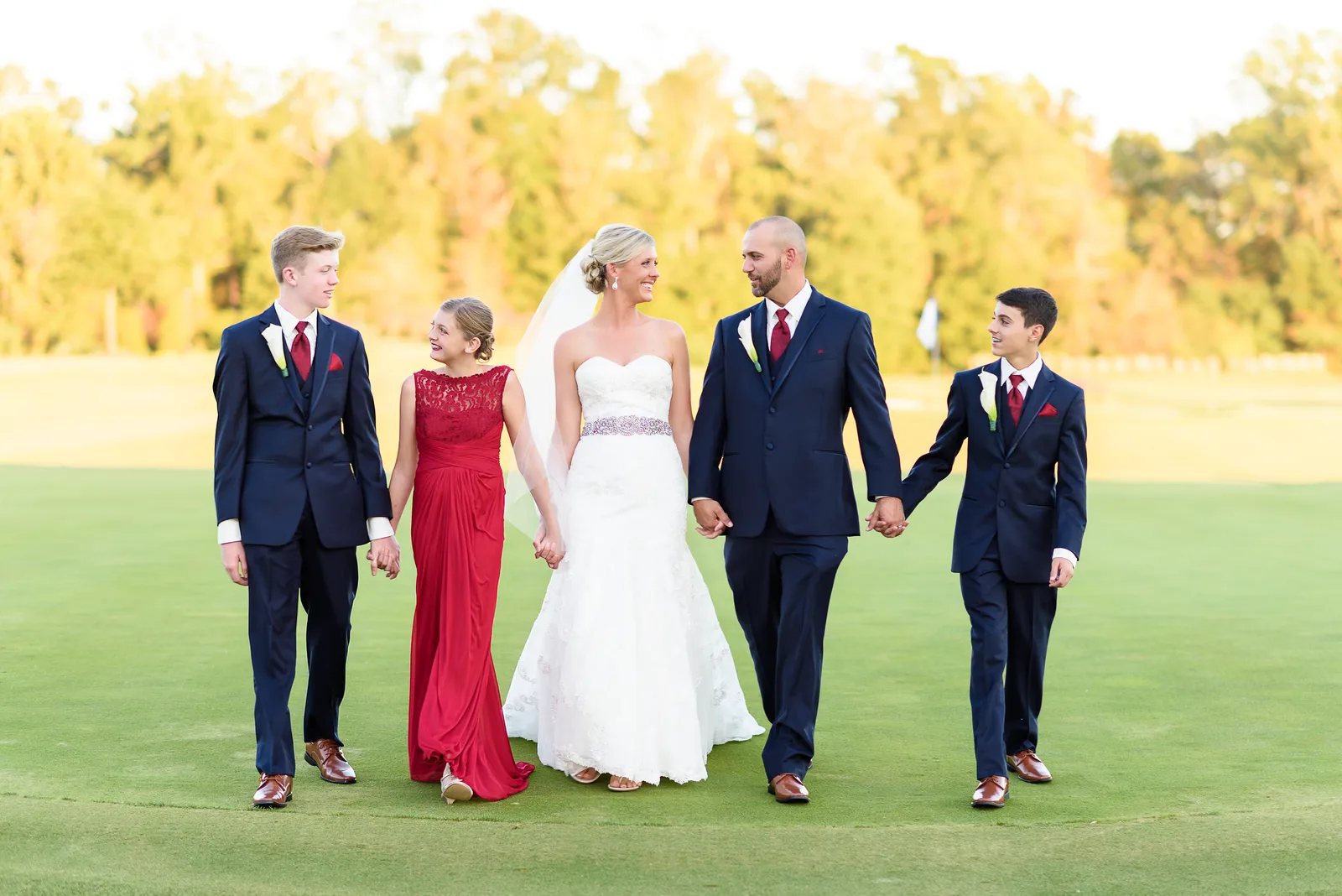 Happy new family walking together on the golf course after the wedding - Members Club - Grande Dunes