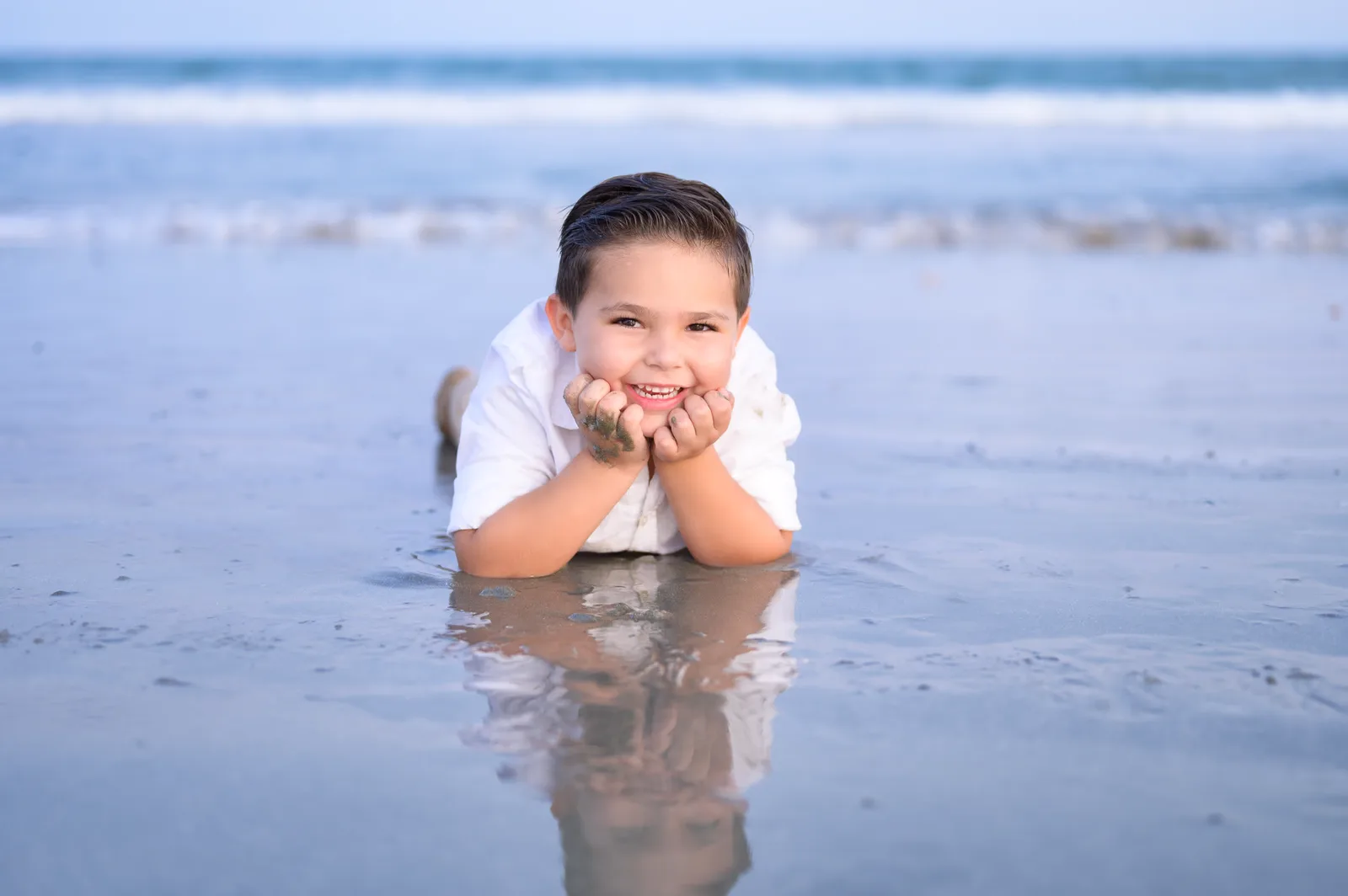 Little boy laying by the ocean - Huntington Beach State Park