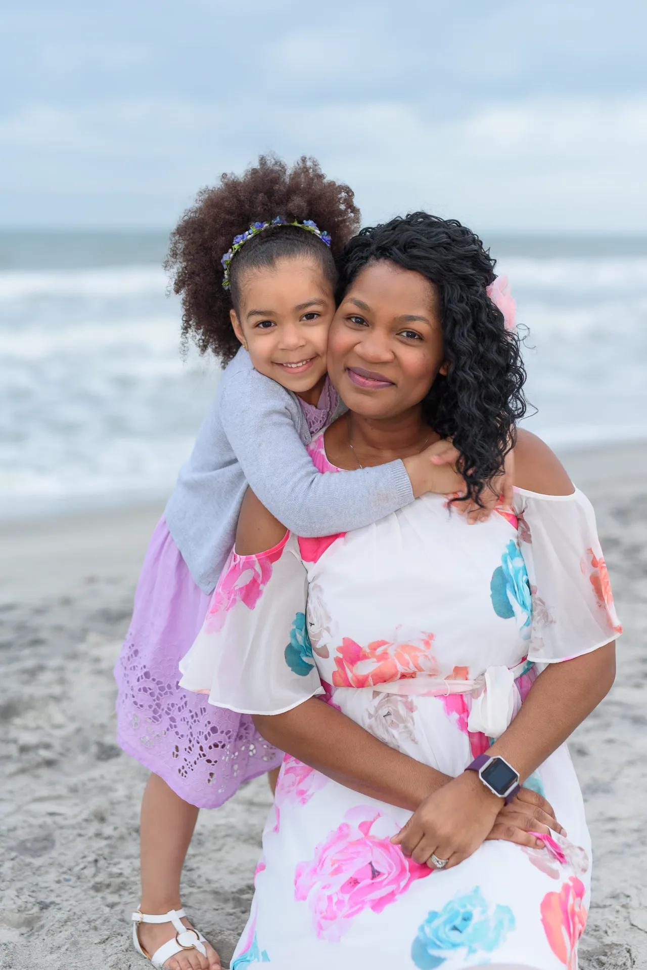 Mom and daughter hugging by the ocean -
