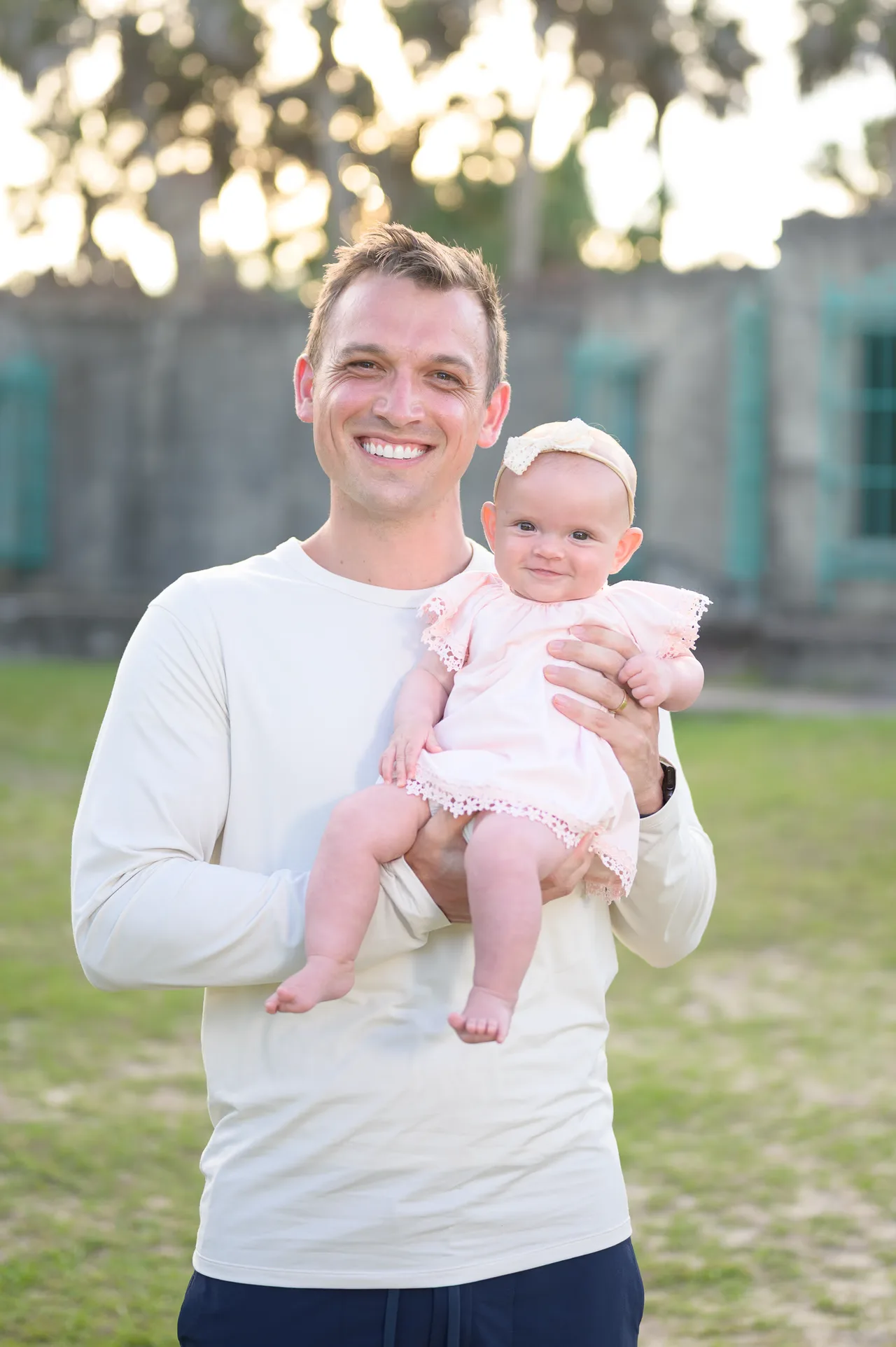 Dad holding baby daughter behind the castle - Huntington Beach State Park