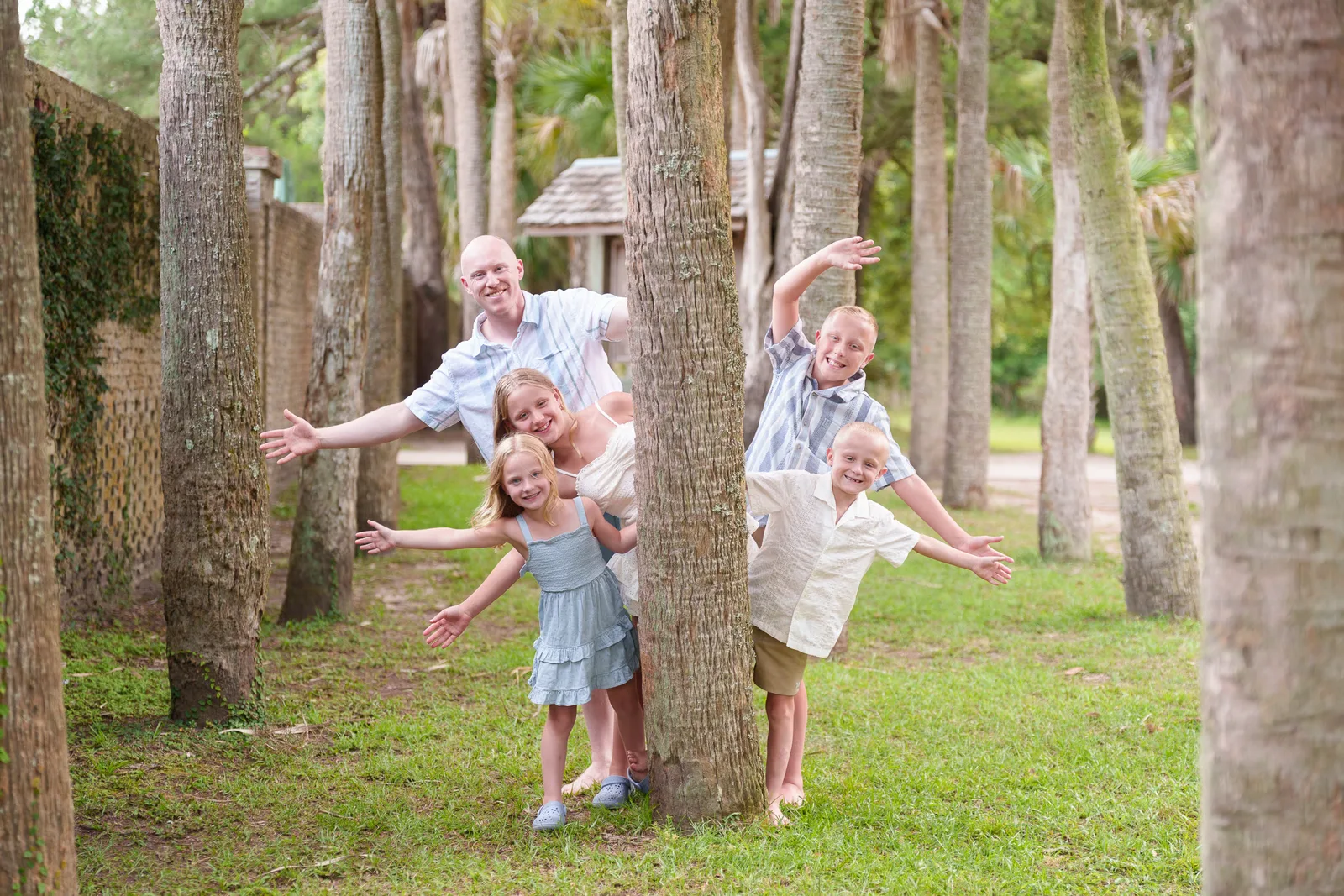 Brothers and sisters having fun around the trees at the park - Huntington Beach State Park