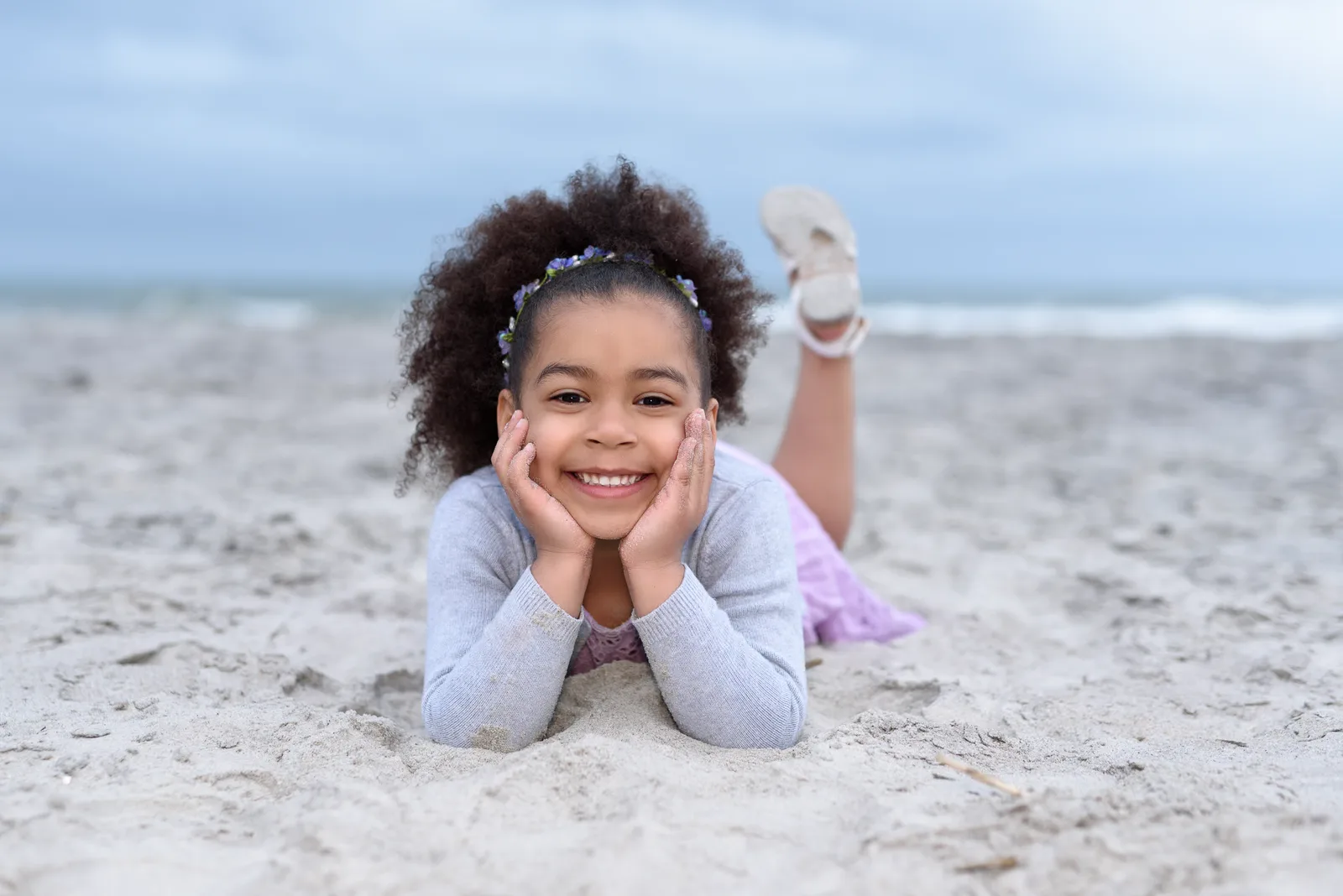 Little girl laying in the sand - Huntington Beach State Park