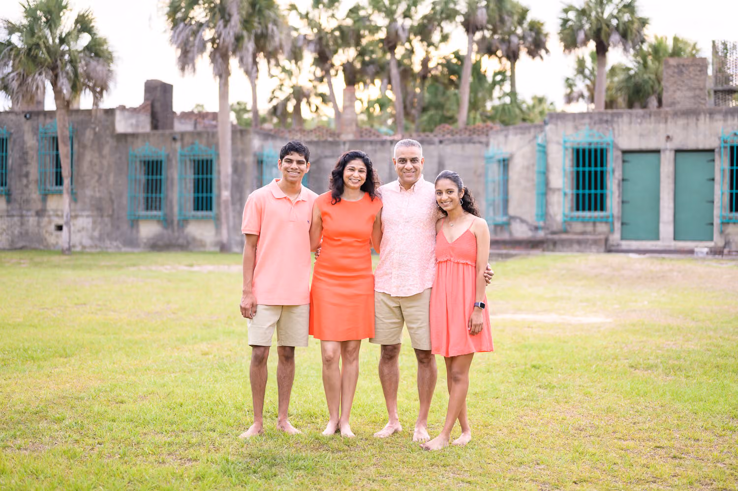 Parents and their grown son and daughter standing on the lawn behind Atalaya Castle at Huntington Beach State Park
