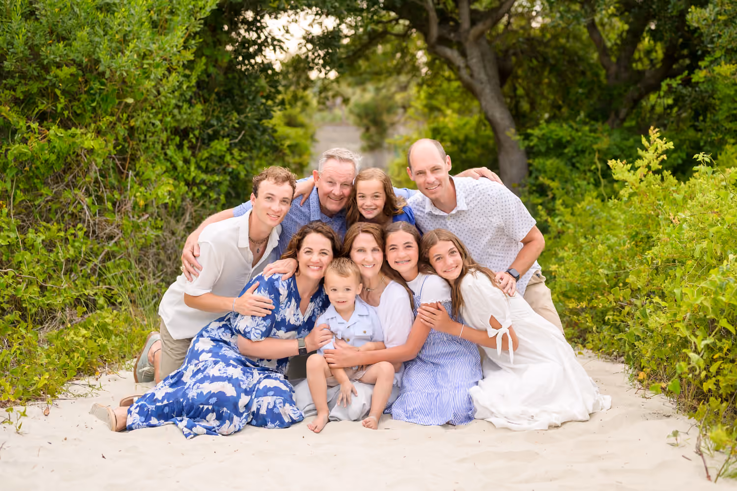 Family embracing together beside the dunes at Huntington Beach State Park.