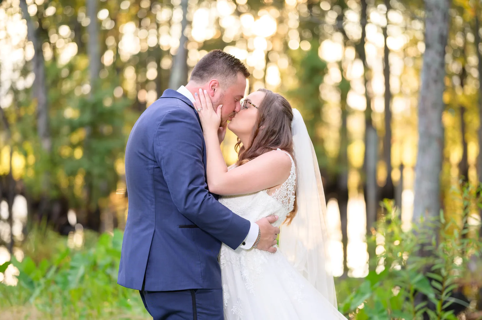Bride with her hands on the groom's cheek pulling him in for a kiss - Wildhorse at Parker Farms