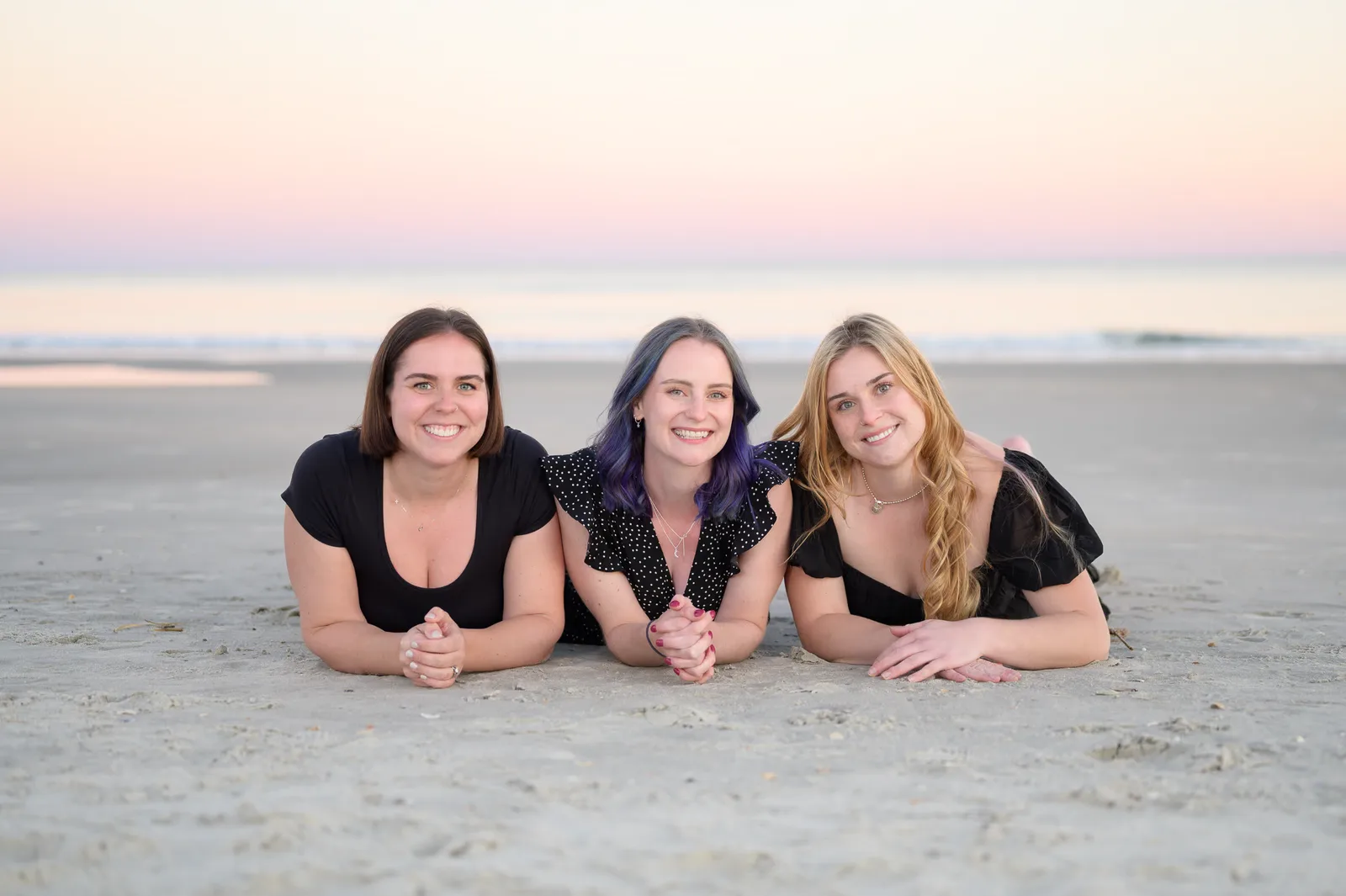 Adult sisters laying together on the sand - Huntington Beach State Park
