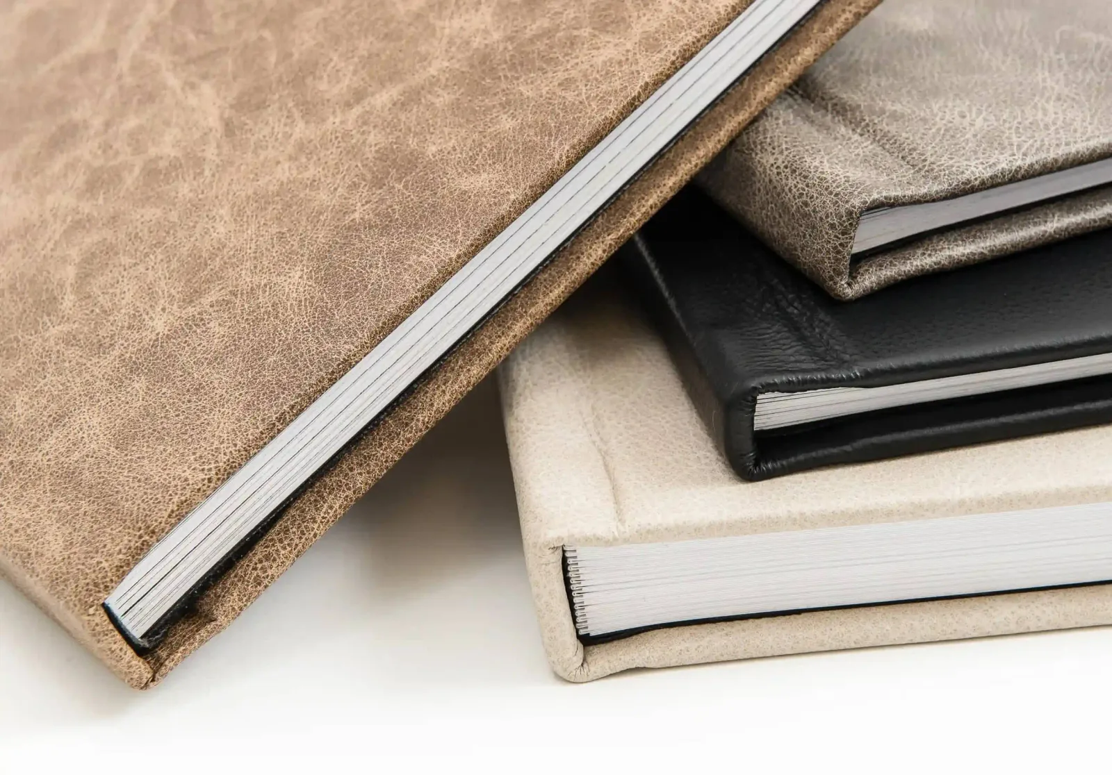 Close-up of stacked albums in distressed tan, black and cream leather