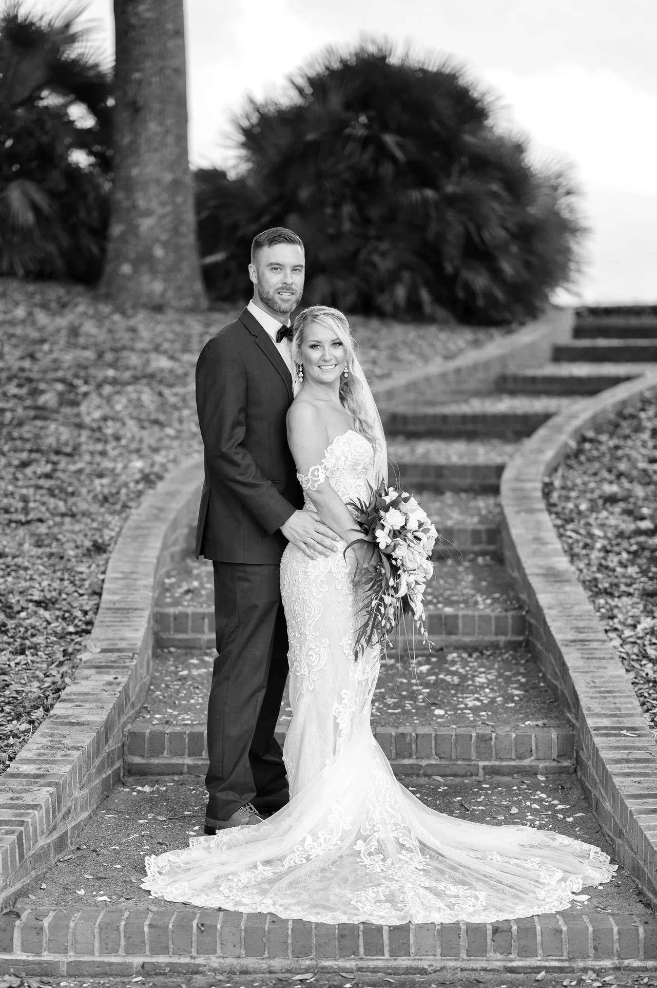 Groom standing behind the bride with her dress pulled around front - Dunes Golf and Beach Club