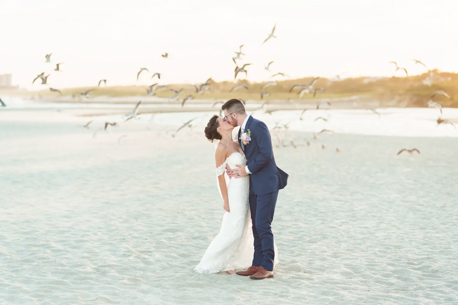 Bridesmaid making the seagulls fly up in the background behind the bride and groom - North Beach Plantation