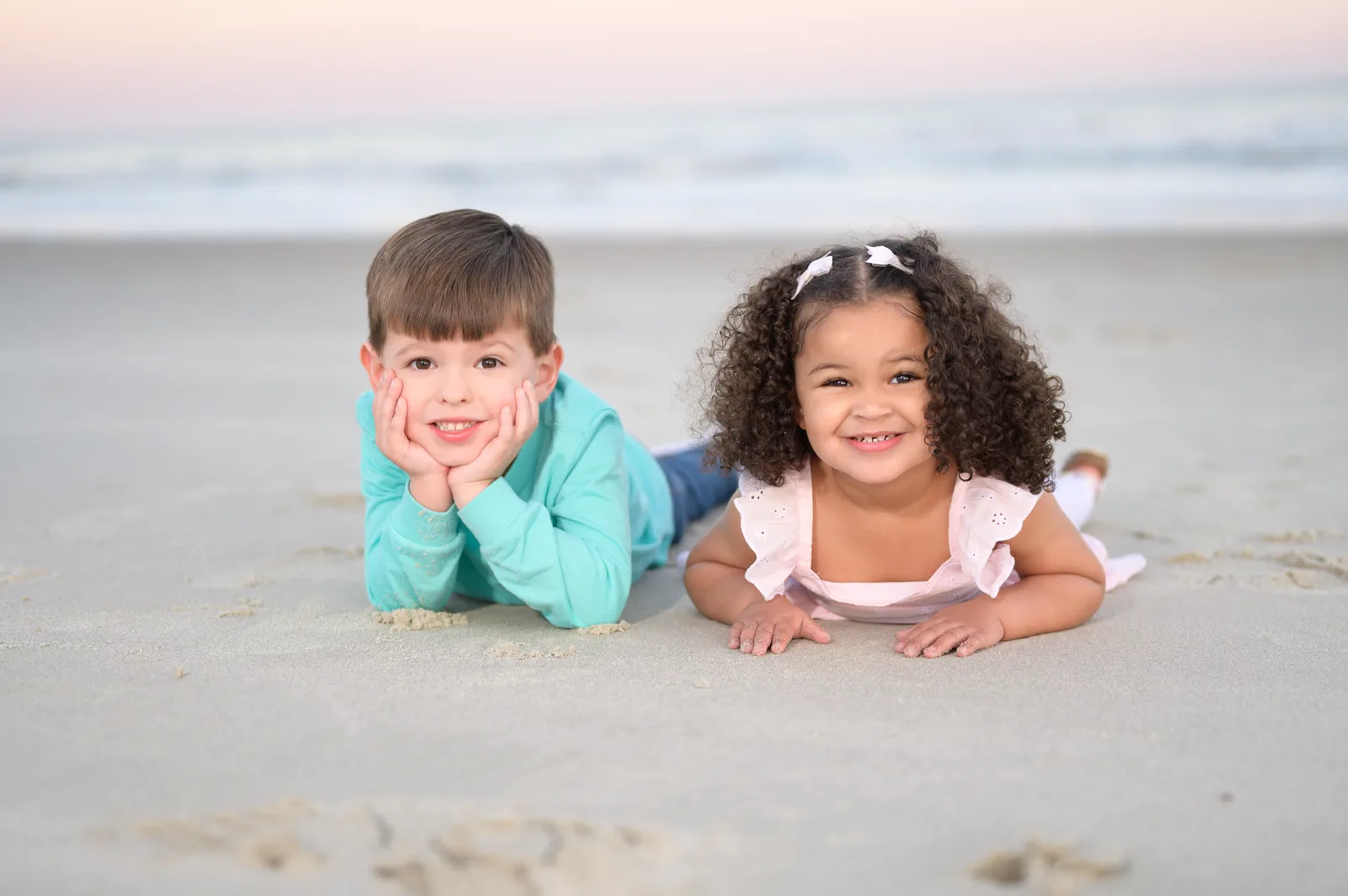 Happy little cousins laying in the sand - Huntington Beach State Park