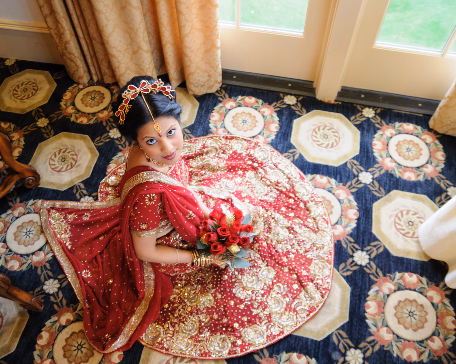 Traditional Indian bride sitting on floor looking up - Grande Dunes Members Club