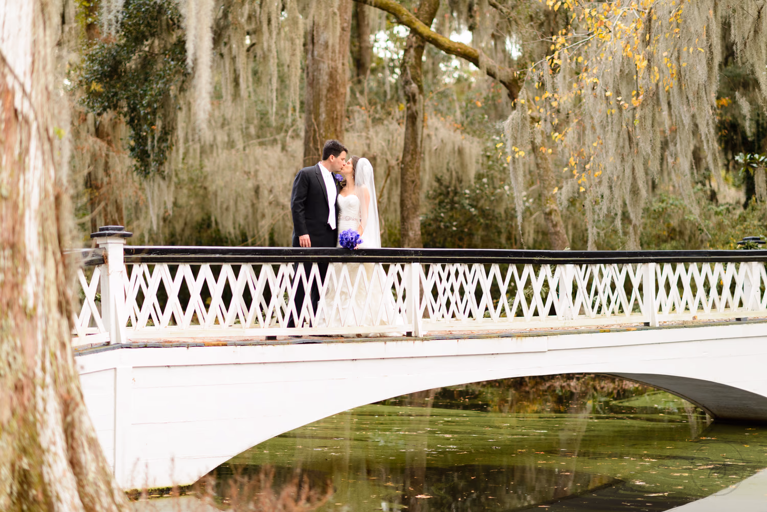 Bride walking with her bridesmaids in purple by the marsh at Magnolia Plantation
