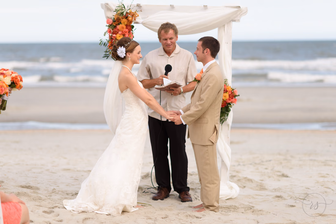 Bride and groom holding hands during ceremony - Hilton Myrtle Beach Resort at Kingston Resorts