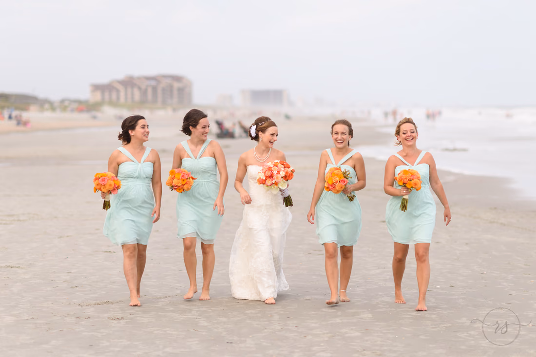 Bride having fun with bridesmaids walking down beach - Hilton Myrtle Beach Resort at Kingston Resorts
