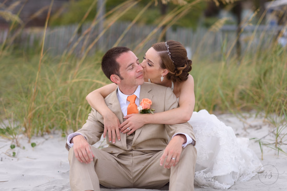 Bride kissing groom on cheek - Hilton Myrtle Beach Resort at Kingston Resorts
