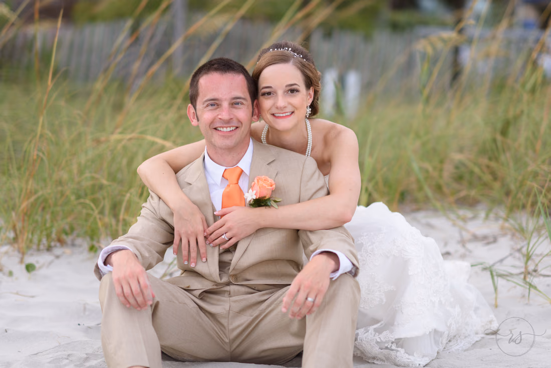 Bride kneeling behind groom with arms around him - Hilton Myrtle Beach Resort at Kingston Resorts
