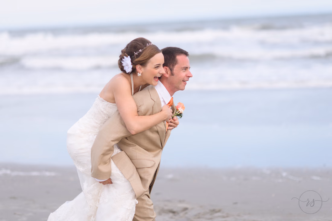Groom giving bride a piggyback ride - Hilton Myrtle Beach Resort at Kingston Resorts