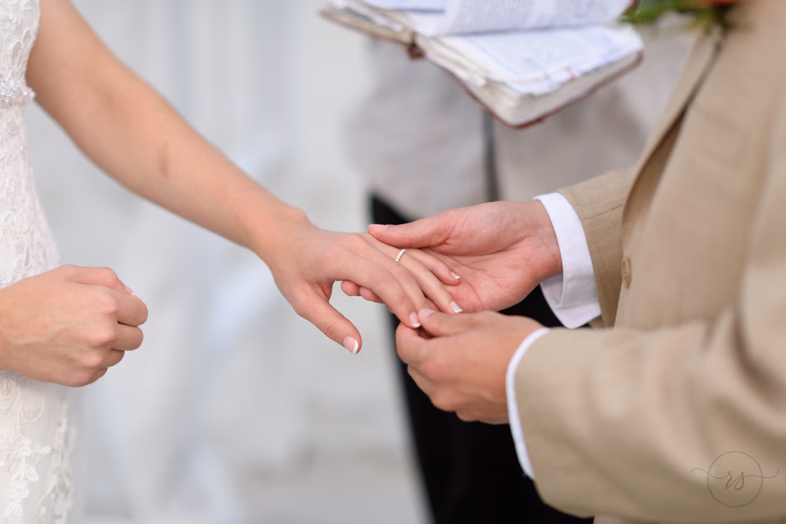Groom holding bride's hand during ceremony - Hilton Myrtle Beach Resort at Kingston Resorts