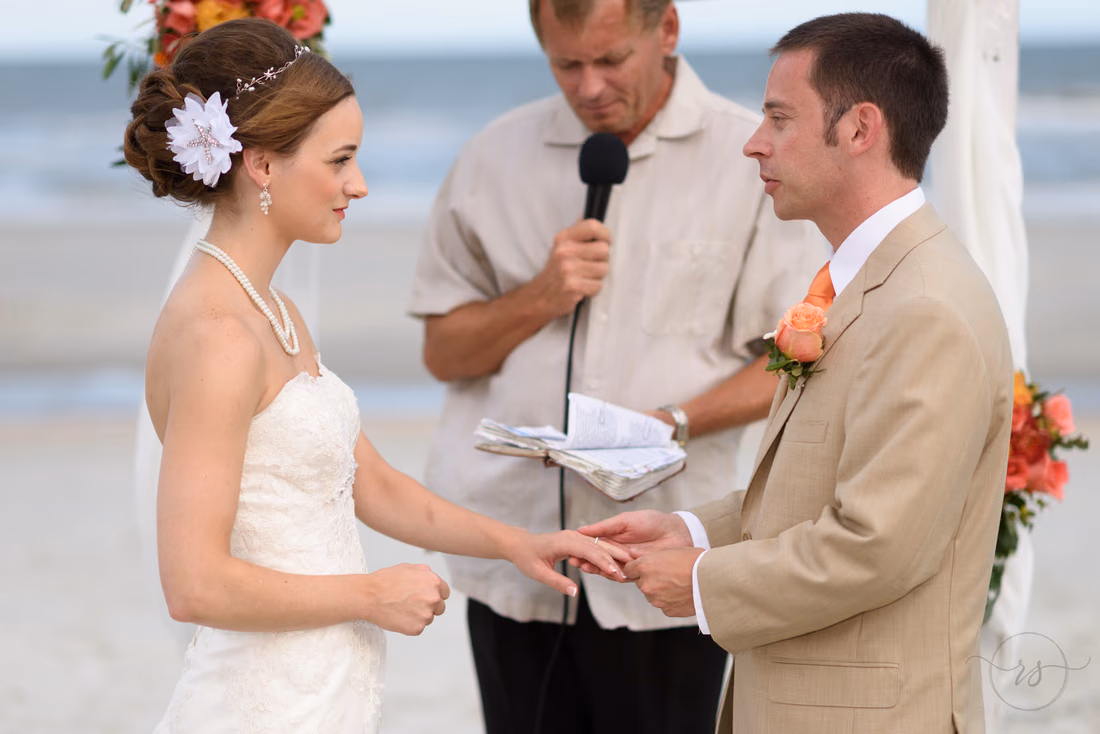 Groom putting on bride's ring - Hilton Myrtle Beach Resort at Kingston Resorts
