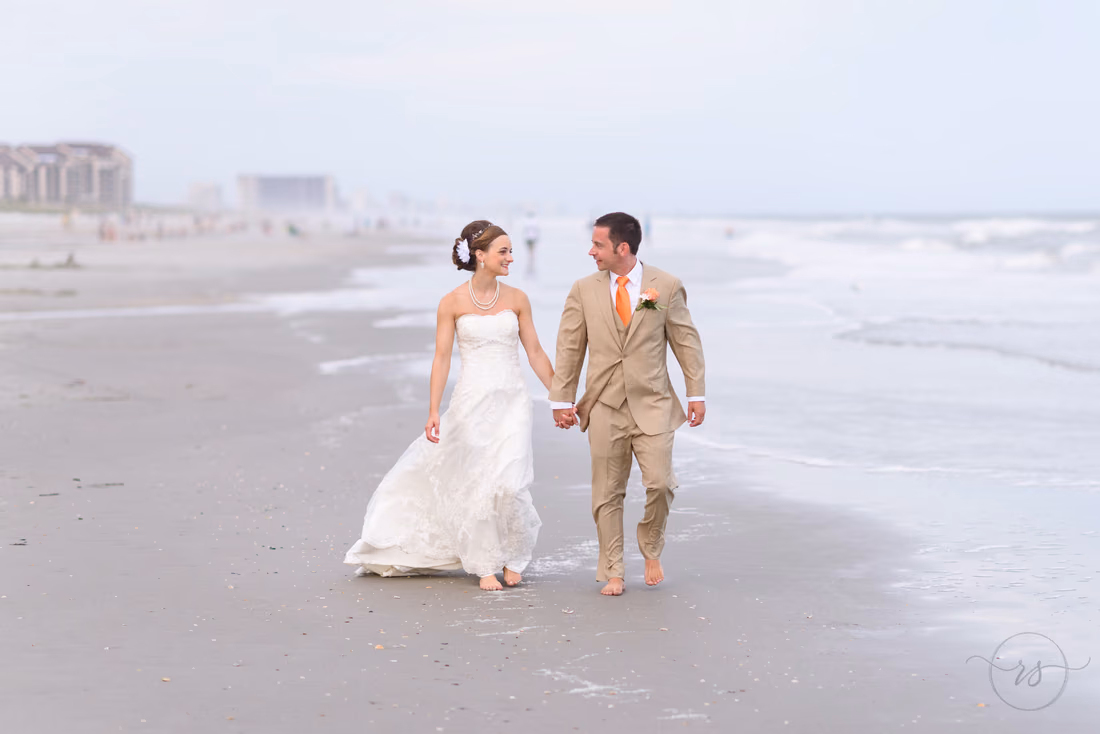 Married couple walking down the beach holding hands - Hilton Myrtle Beach Resort at Kingston Resorts