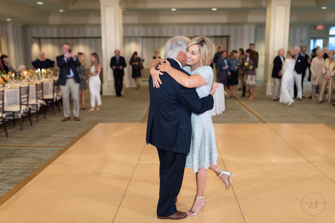Bride kicks up her heel as she hugs the groom during their first dance at the Dunes Golf and Beach Club in Myrtle Beach