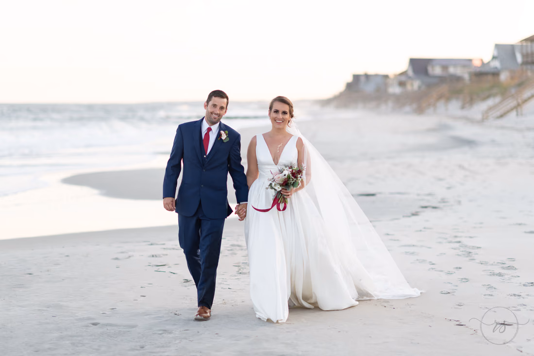 Happy bride and groom walking down the beach - Pelican Inn - Pawleys Island