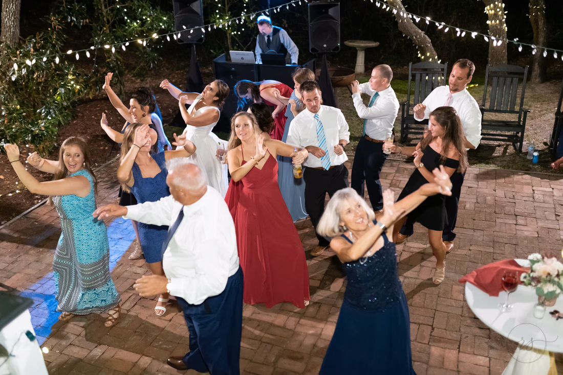 Guests dancing with their arms out under the string lights - Pelican Inn - Pawleys Island