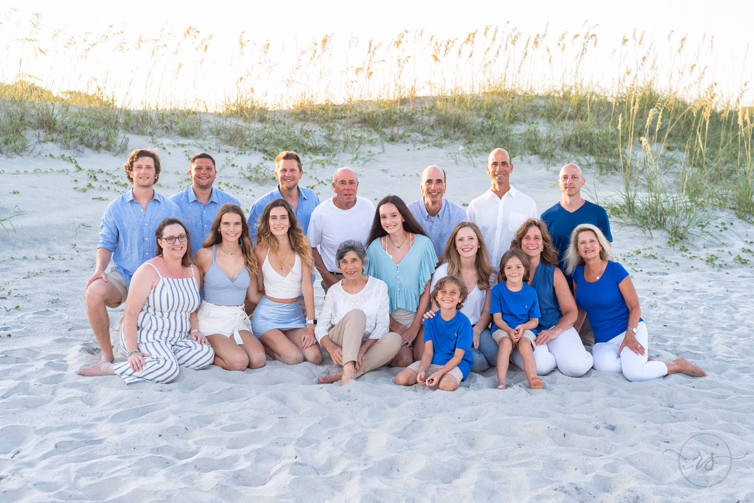 Large family dressed in blue standing in front of the sea oats at Huntington Beach State Park