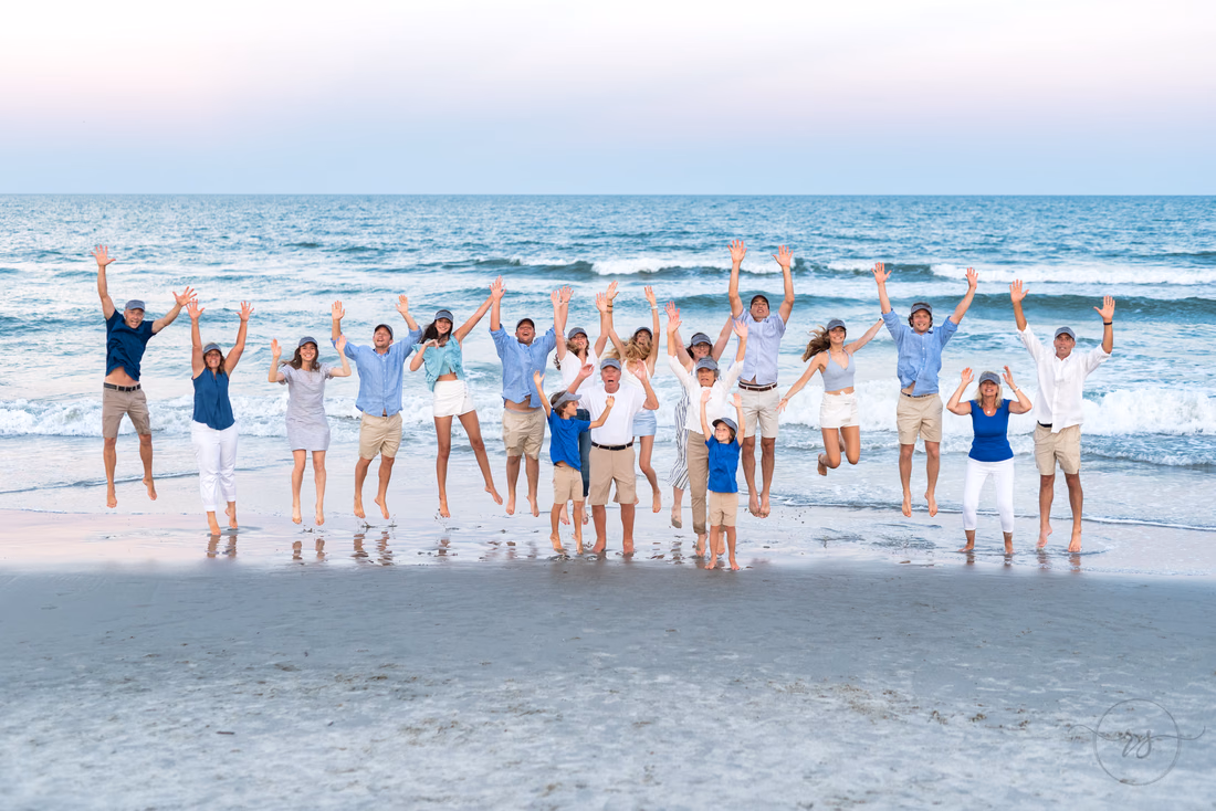 Family jumping together at the water's edge at Huntington Beach State Park
