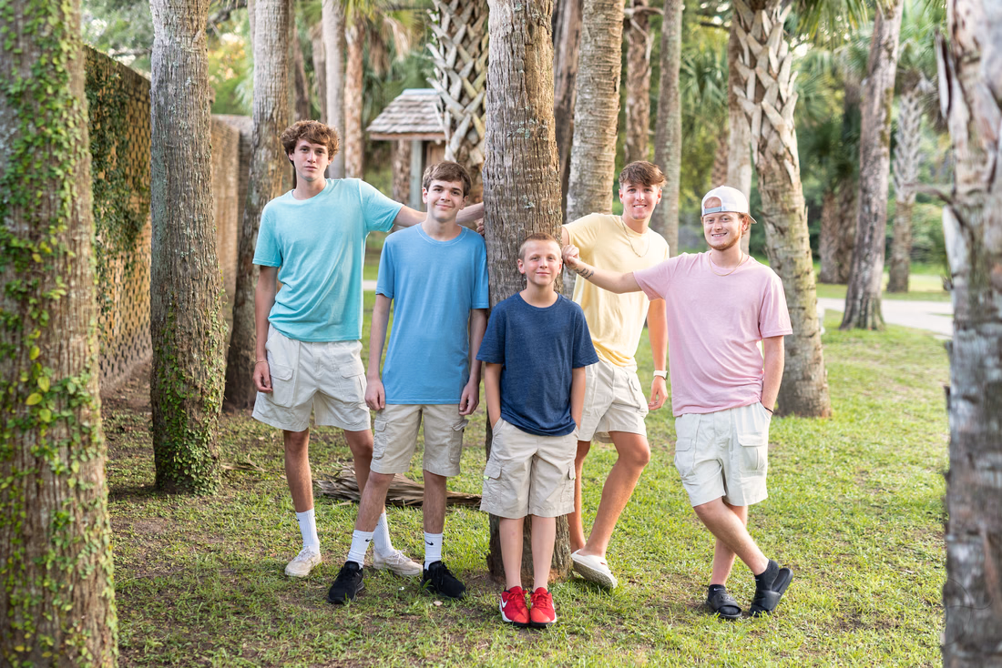 Boys posing under the palm trees at Huntington Beach State Park