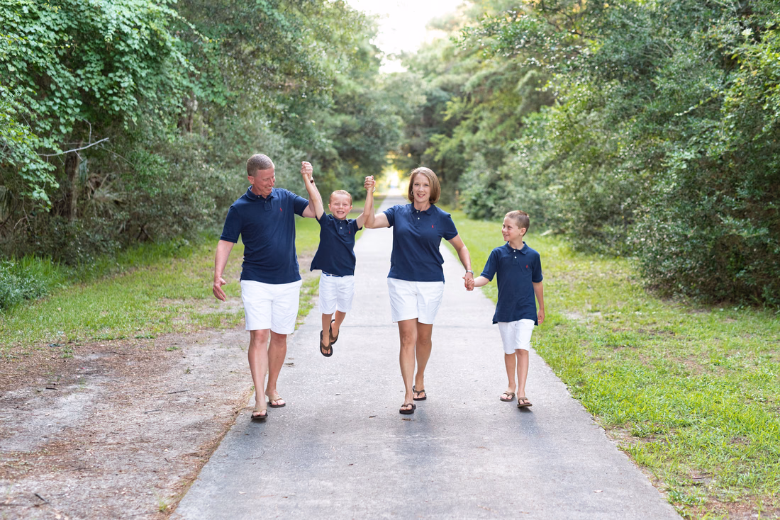 Family walking down the shaded path at Huntington Beach State Park