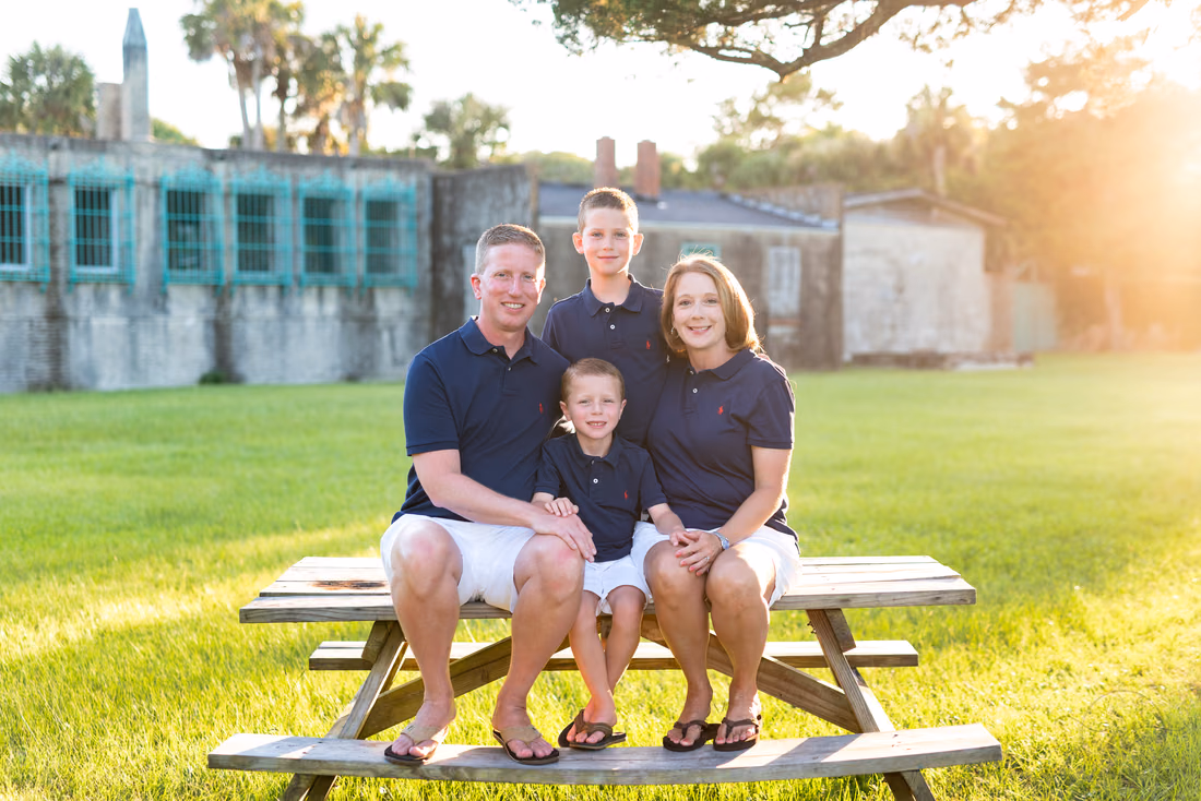 Family sitting on a picnic table near Atalaya Castle at Huntington Beach State Park