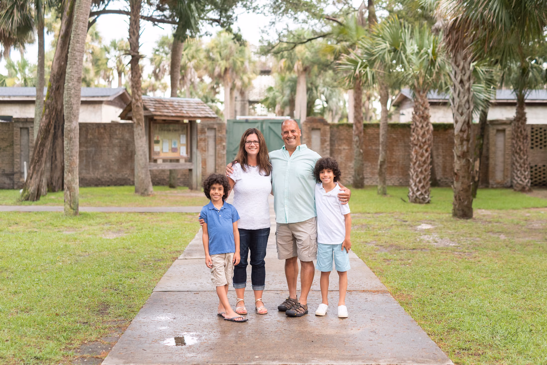 Family of four standing by Atalaya Castle at Huntington Beach State Park