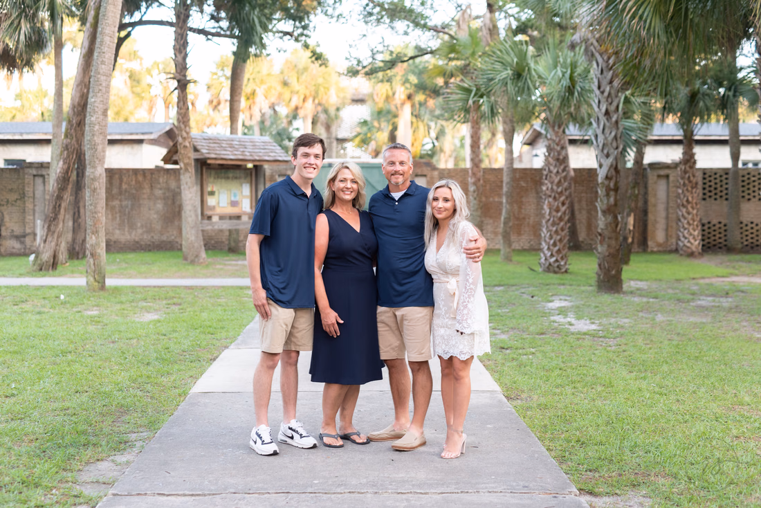 Family in navy and white standing on the path near Atalaya Castle at Huntington Beach State Park