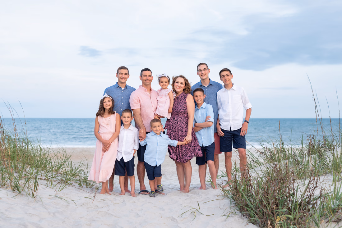 Parents and their kids standing between the sea oats on the beach at Huntington Beach State Park