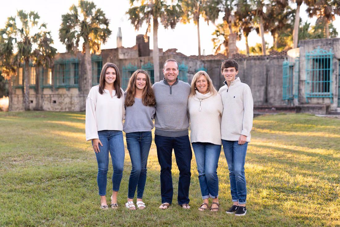 Family of five with adult kids on the lawn in front of Atalaya Castle at Huntington Beach State Park
