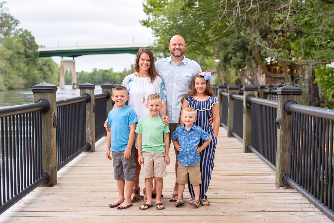 Parents and their five kids on the boardwalk by the bridge at the Conway Riverwalk