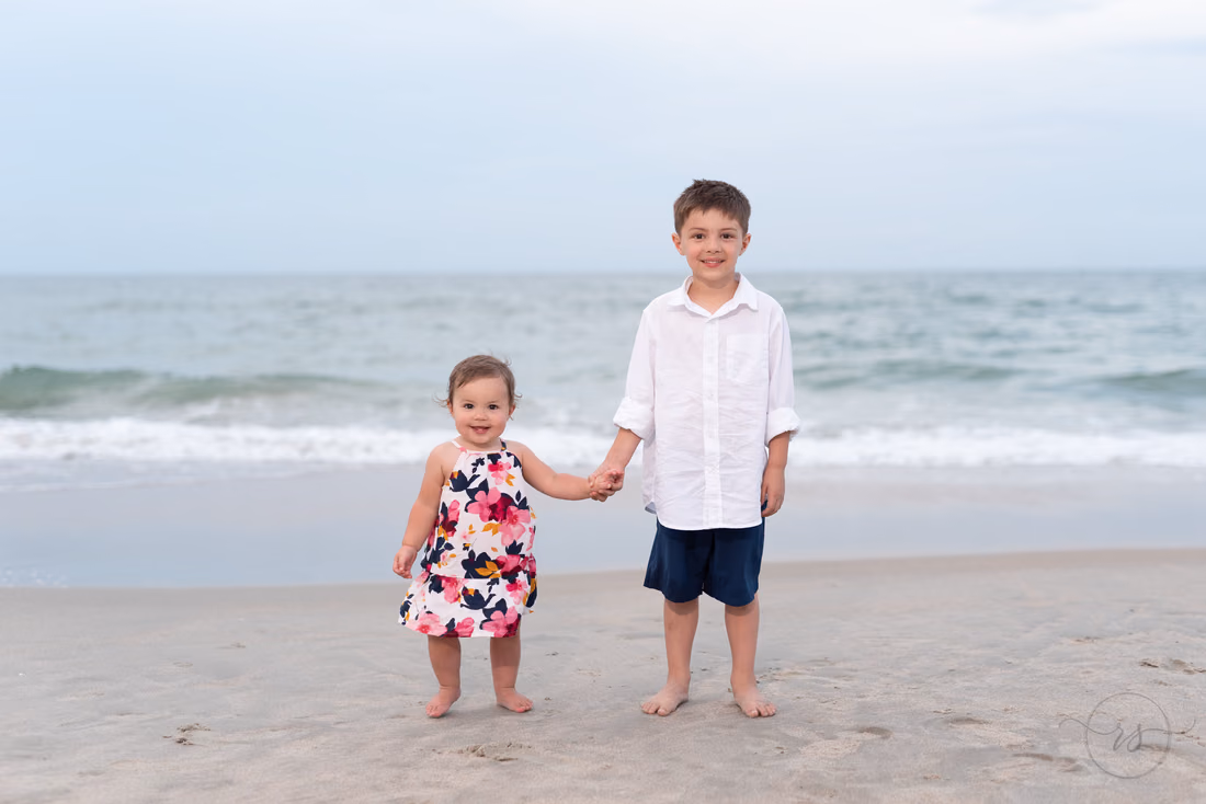 Little brother and sister holding hands in front of the ocean - Huntington Beach State Park