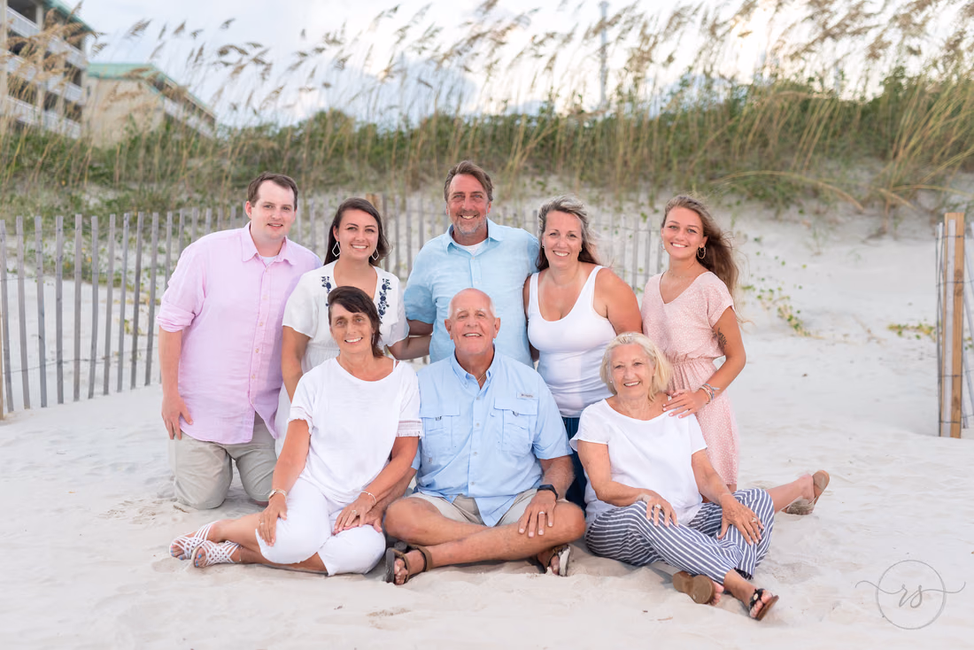 Extended family gathered by the dunes and sand fence for maternity portraits at Litchfield Beach